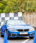 Car navigating blue traffic cones at driving practice area