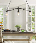 Farmhouse Chandelier Hanging Light Fixture in Rustic Black Metal with Three Bowl Shaped Clear Glass Shades over Dining Room Table