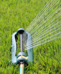 TurboTek Oscillating Sprinkler with 16 precision nozzles spraying water on grass, flexible tubing visible, green and yellow design