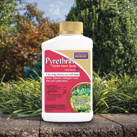 Pyrethrin Garden Insect Spray Concentrate 8 Oz Ready To Mix bottle with garden background, insecticide kills pests in gardens