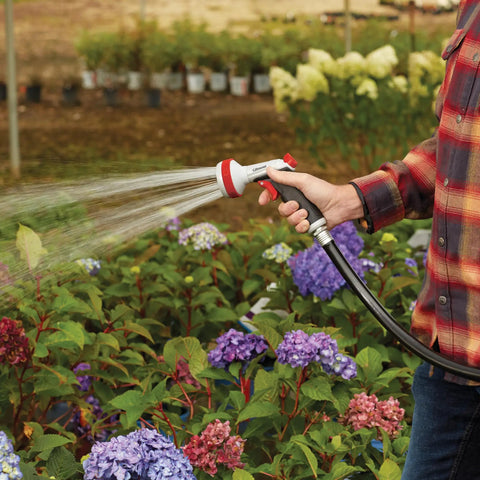 Person using Heavy Duty Garden Hose Nozzle With Five Adjustable Spray Patterns For Lawn And Garden Jet Shower Mist Sweep Fill