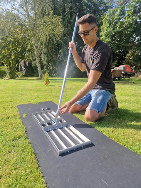 Person using 38 Inch Wide Leveling Lawn Rake with Stainless Steel Head and 72 Inch Aluminum Handle on grass