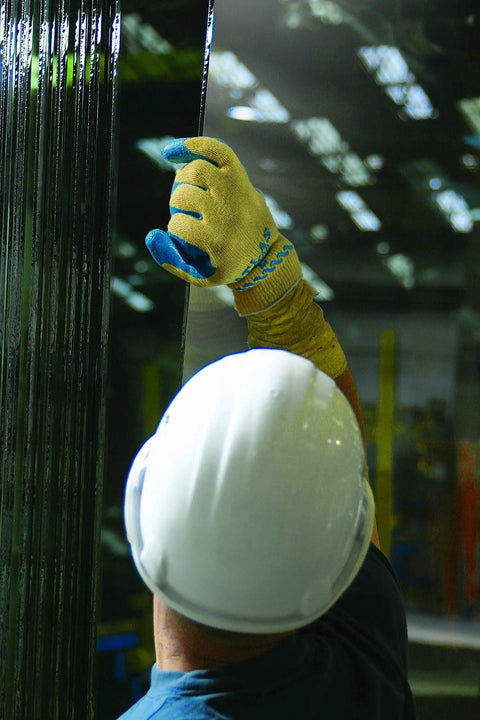 Worker using Heavy Duty Latex Palm Coated Safety Gloves With Kevlar Liner For Cut Resistance A3, handling industrial materials.