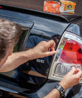 Man applying Crystal Clear Duct Tape 1.88 Inch by 9 Yard Heavy Duty All Purpose Tape Weatherproof Clear Repair Tape on car tail light