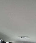 Auto headliner fabric mesh, light gray, foam-backed interior roof, installed in a vehicle with overhead light.