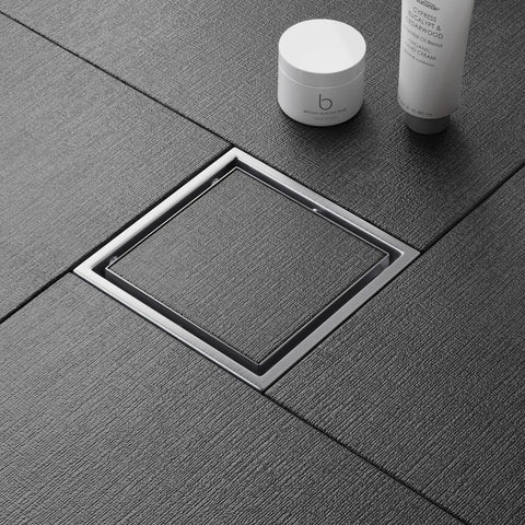 6 Inch Square Shower Drain With Flush Mount Tile Grate And Heavy Duty Hair Catcher Fast Flow Brushed Nickel Stainless Steel Rust Free Floor Drain on textured bathroom floor.