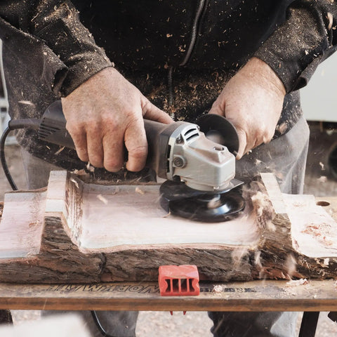 Person using TurboPlane Carbide Woodworking Blade For Angle Grinders, 4 Inch Disc Attachment on a wooden surface