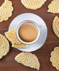 Cute Mini Electric Pizzelle Maker Creates Single 4 Inch Italian Waffle Cookies served with coffee on a wooden table.