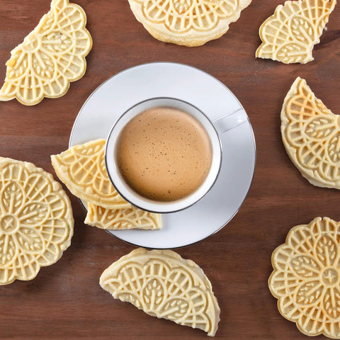 Cute Mini Electric Pizzelle Maker Creates Single 4 Inch Italian Waffle Cookies served with coffee on a wooden table.