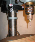 Drill Press Laser Crosshair Guide For Precise Drilling In Your Shop installed on benchtop drill press showing red crosshair.