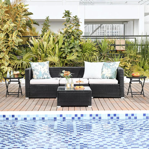 Outdoor Folding Round Patio End Table With Silk Tempered Glass Top And Lightweight Steel Frame beside a poolside sofa.