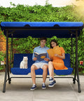 Cozy Three Seat Patio Swing With Adjustable Canopy And Built In Side Tables, Outdoor Porch Glider With Stand For Adults, 2 In 1 Convertible Swing Chair For Patio Garden Or Backyard, Blue showcasing a couple and a cat seated outdoors under the canopy.