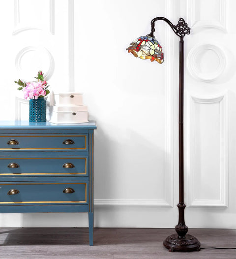 Dragonfly Tiffany-Style 60-Inch Arched LED Floor Lamp in Bronze next to a blue dresser, lit up with energy-saving LED bulbs included.