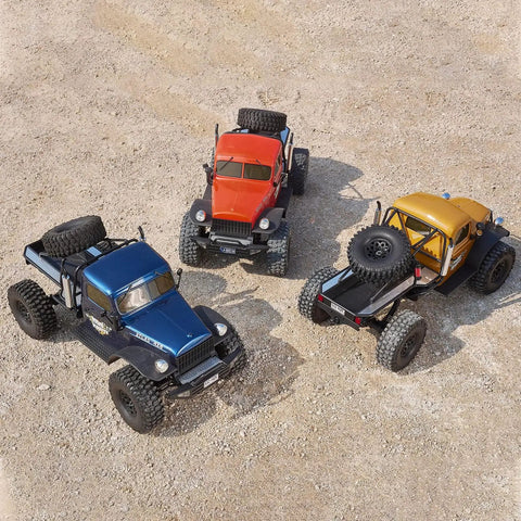 Top view of three Atlas S One Tenth RC Crawler Four By Four Beast Off Road Rock Trucks on gravel for adults