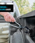 Hand using CamJam SlideLock Rope Tightener with Quick Release Lever to secure rope in truck bed, cast aluminum tensioner visible.