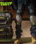 Person wearing dual gel foam knee pads with comfort hinge and non marring caps for heavy duty flooring and construction