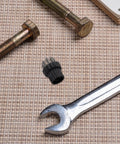 Ten Piece Steam Cleaner Brush Head Replacement Kit Featuring Heavy Duty Copper And Steel Bristles For Slick Groove Scrubbing Knocking Out Stubborn Grime On Portable Steam Mops with tools and bolts on textured background.