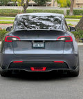 Dope Tesla Model Y Led Brake And Turn Signal Kit With Smoke Tint Lens installed on a gray Tesla rear view.