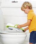 Child placing No Fuss Toddler Potty Training Seat With Rock Solid Non Slip Base Secure Handgrips And Quick Wipe Plastic Body For Smooth Potty Learning Journey In Bright Green on a toilet.