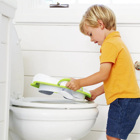 Child placing No Fuss Toddler Potty Training Seat With Rock Solid Non Slip Base Secure Handgrips And Quick Wipe Plastic Body For Smooth Potty Learning Journey In Bright Green on a toilet.