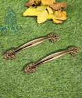 Elegant Antique Brass Cabinet Handle With Dope Ornate Vintage Leaf Design Pair Drawer And Door Pull For Furniture Restoration And Home Decor 12 Inch Sturdy Brass Hardware Built To Last For Cabinets And Dressers displayed on grass with autumn leaves in background.