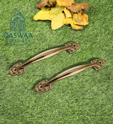 Elegant Antique Brass Cabinet Handle With Dope Ornate Vintage Leaf Design Pair Drawer And Door Pull For Furniture Restoration And Home Decor 12 Inch Sturdy Brass Hardware Built To Last For Cabinets And Dressers displayed on grass with autumn leaves in background.