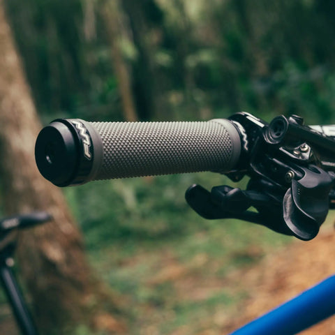 Double Lock On Clamp Mountain Bike Grips With Diamond Pattern for MTB and BMX 22 mm Inner Diameter, white grip in forest setting