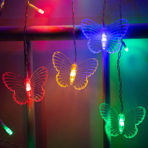 Multicolor Butterfly Curtain Lights 13ft 96 LED Fairy String With Remote hanging on rod, glowing in dark