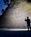 Person using 650 Lumen LED Flashlight With Slide Focus And Beam Lock Pure Beam Focusing Optics For Spot To Flood Control on beach