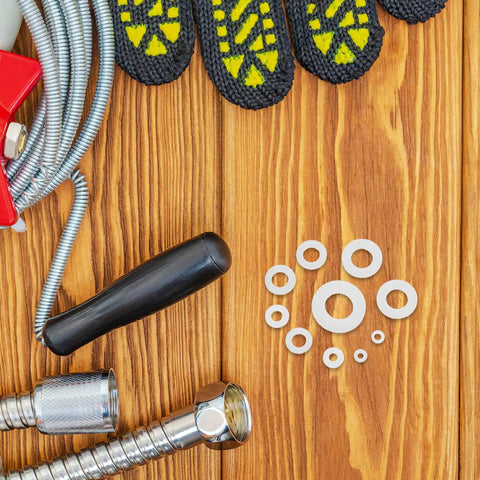 White Nylon Flat Washers Set 500 Piece Assortment M2 To M8 In Sizes, Durable Insulated Gasket Washers For Automotive, Marine, Machinery, And Mounting Hardware, Corrosion Resistant, Easy Fit And Quick Install. White nylon washers on wood with hoses and fittings.