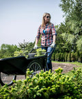 Woman using Beefy Heavy Duty Utility Cart With 10 Cubic Feet Tub And 400 Pound Load Capacity With Flat Free Wheels in garden