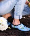 Women's Waterproof Rain Kicks Slip-On Garden Clog With Heavy-Duty Arch Support And All-Day Cushy Comfort For Busting Through Puddles And Tackling Yard Chores In Light Blue Bee Print, worn while gardening.