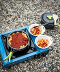 Camping Cookware 18 Piece Mess Kit With Backpacking Stove on gravel, cooking pasta meal in durable anodized aluminum pan