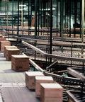 Conveyor system with cardboard boxes moving through a warehouse distribution area.