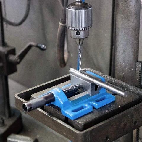 5 Inch Unigrip Drill Press Vise with 4-3/8 Inch Jaw Opening on drill press, gripping metal rod securely for precise work