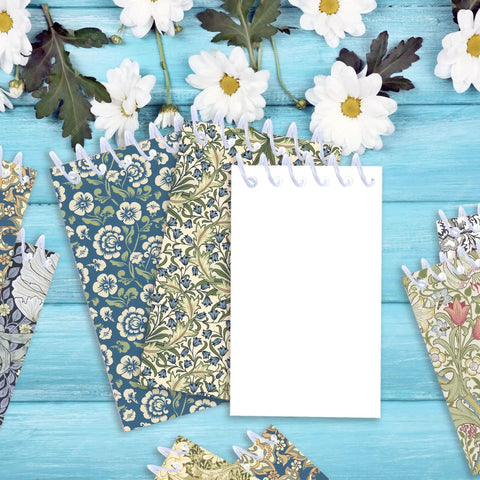 Mini Pocket Spiral Notebooks Bundle - 24 Count, 2.36 x 3.94 Inches, 8 Vintage William Morris Floral Covers next to daisies