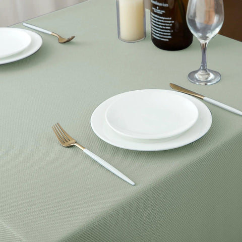54x54 Inch Sage Square Tablecloth, Linen Like, Water Resistant And Washable on dining table with plates and cutlery
