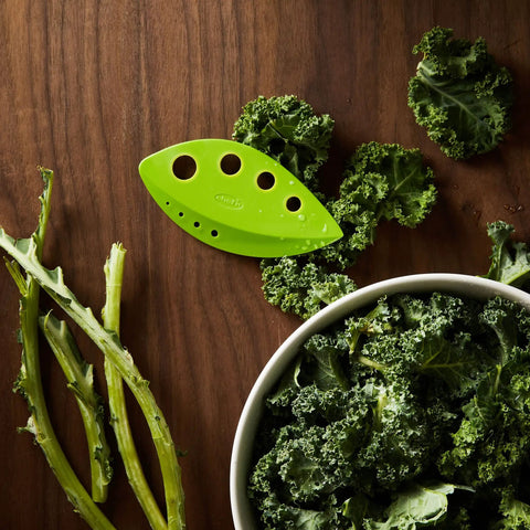 Zero Stress Leaf Stripper For Fresh Kale And Collard Greens With Super Sharp Curved Cutting Edge Quick Herb Chopper Kitchen Gadget on wooden surface with kale and stems.
