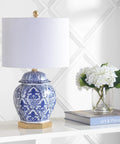 Blue And White Ginger Jar Ceramic LED Table Lamp With Gold Base And White Linen Shade on a table in a living room setting.