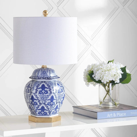 Blue And White Ginger Jar Ceramic LED Table Lamp With Gold Base And White Linen Shade on a table in a living room setting.