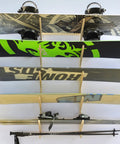Premium Wall Rack Mount For Ski Snowboard And Longboard Storage Featuring Adjustable Baltic Birch Arms holding multiple snowboards and skis.