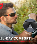 Person wearing green tinted wraparound safety glasses with adjustable arms, highlighted no slip grips, for all-day comfort and impact protection