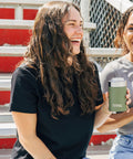 Heavy Duty 12 Oz Can Cooler With Tight Seal Lid Double Wall Vacuum Insulated Stainless Steel Chiller Keeps Beer And Soda Bangin Cold Zero Sweat Build Olive in use by two women outdoors.