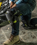 Worker wearing Dual Gel Foam Knee Pads with Comfort Hinge on construction site, showcasing all-day cushioning and non-marring caps.