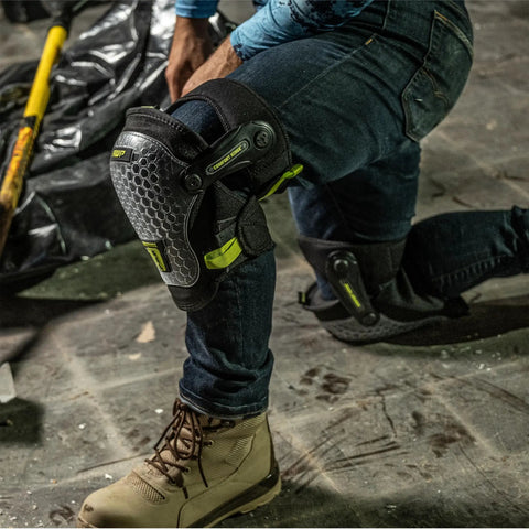 Worker wearing Dual Gel Foam Knee Pads with Comfort Hinge on construction site, showcasing all-day cushioning and non-marring caps.