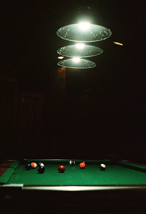 Three Light Pulley Pendant Island Light With Industrial Vintage Rustic Vibe over pool table in dimly lit game room