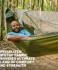 Person relaxing in JungleNest Pacific Hammock with Extended 10 Foot Length Structural Ridgeline and integrated bug net