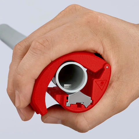 Hand using Pipe Cutter For Plastic Pipes 20 To 50 mm That Cuts Without Shavings, Ergonomic Handle, on gray pipe