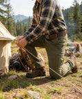 Man setting up a tent wearing 6 Pack Tactical Belt For Men With Heavy Duty POM Buckle Metal Free Nylon Web Belt 1.5 Inch Wide 49 Inch Long
