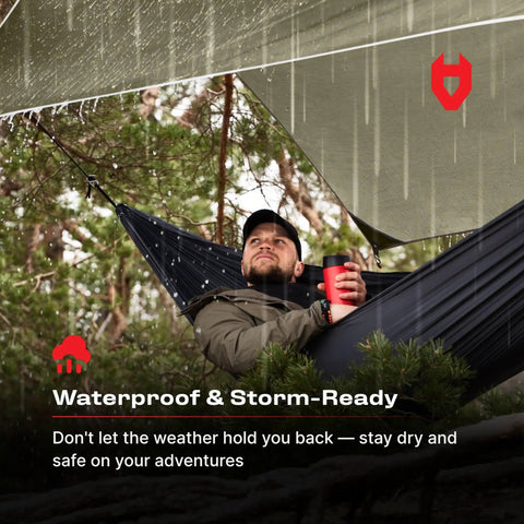 Man in hammock under 12x10 Rain Fly Tarp For Survival Camping, Ultra Lightweight Waterproof Shelter, OD Green.